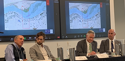 Panelists seated at table in front of river map