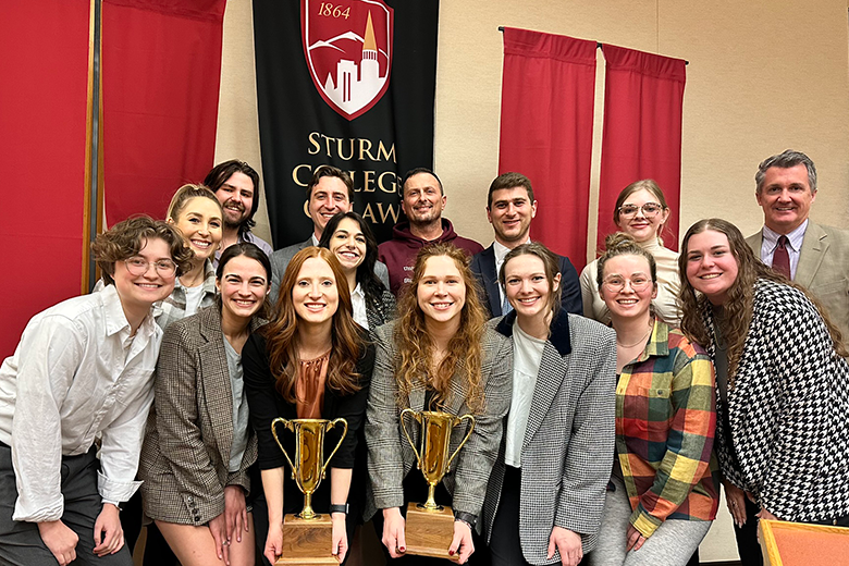 students posing with trophies