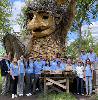 group photo in front of wooden troll sculpture