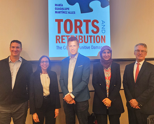 Group of five individuals standing in front of screen showing book cover