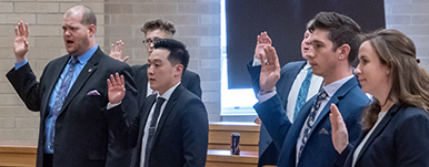 students raising hands to take oath