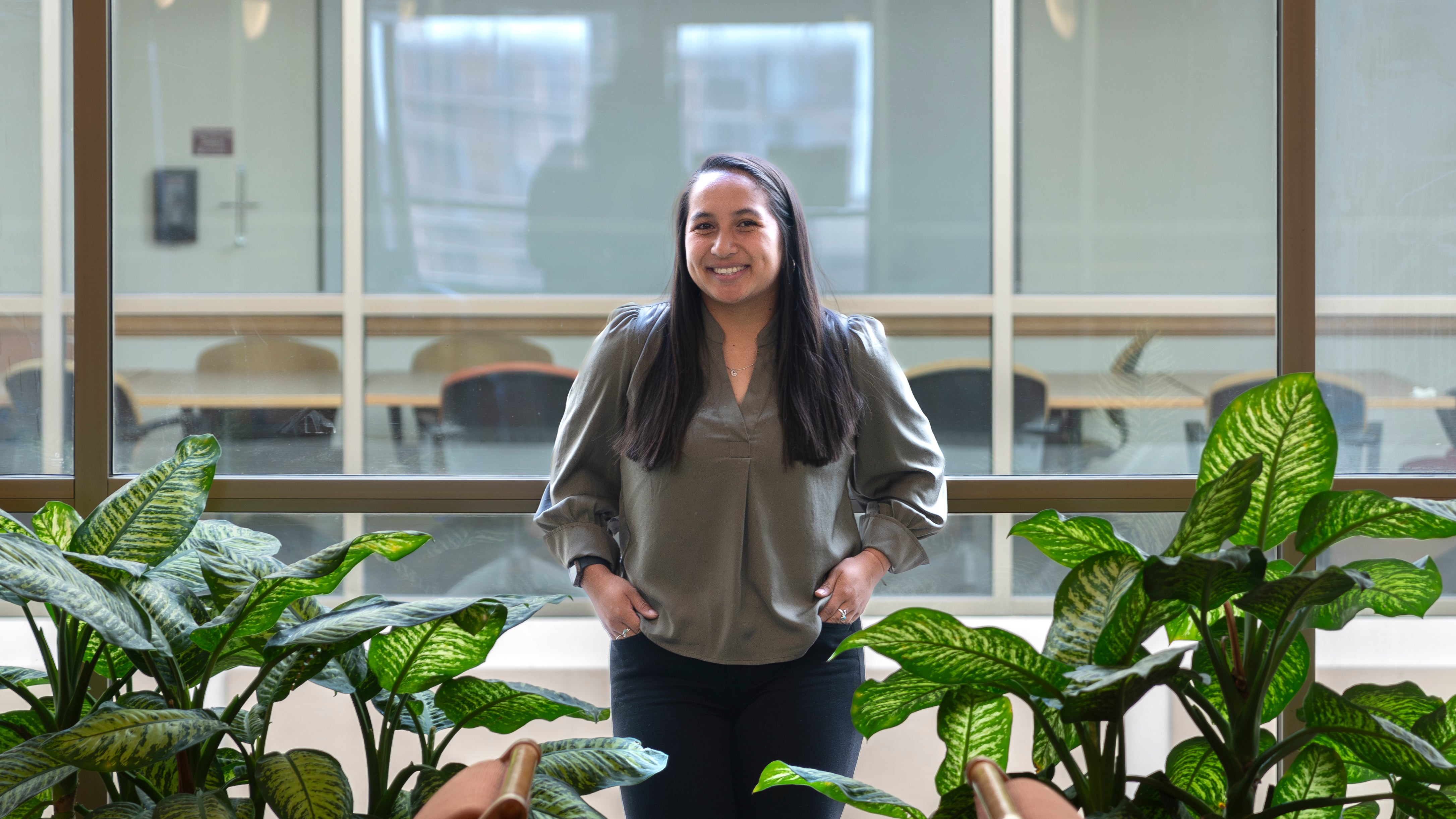 DU Sturm Law student Caley Carlson poses for a photo among greenery in the Sturm College of Law.