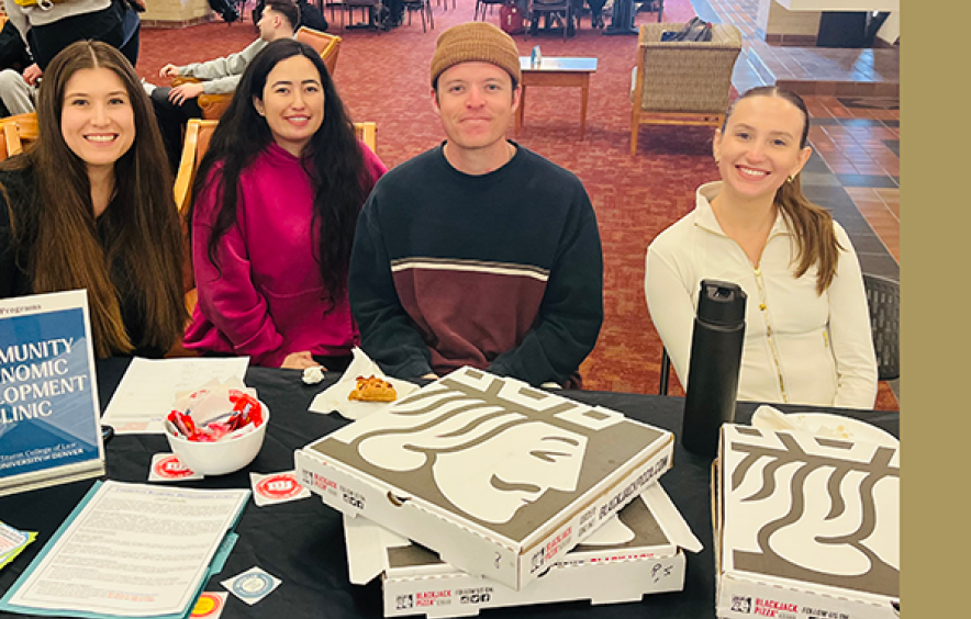 four students seated at information table