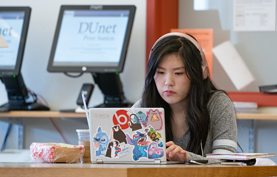 student using laptop with headphones on
