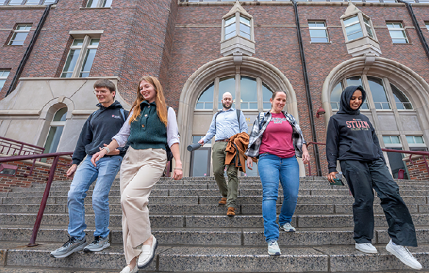students walking down steps in front of law building