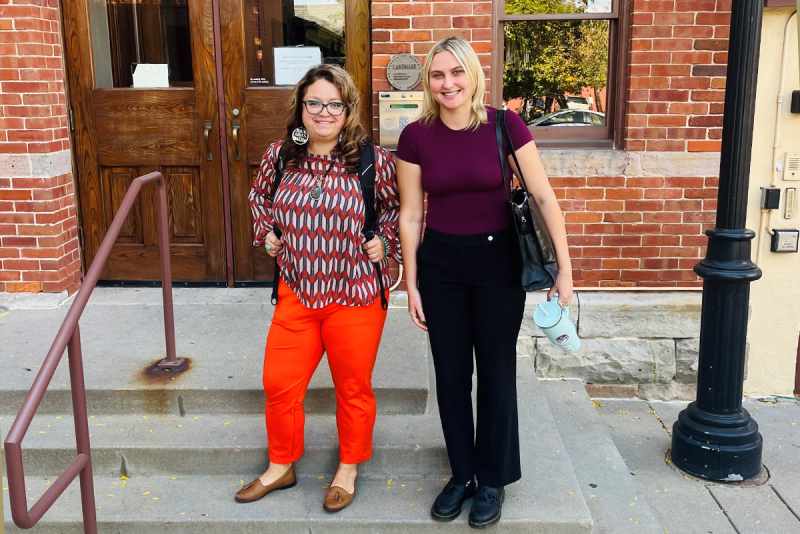Two Advancing Social Change Clinic students standing on steps of building