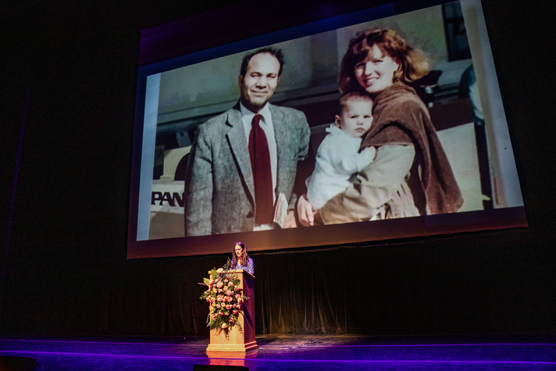 woman standing at podium in front of slide show