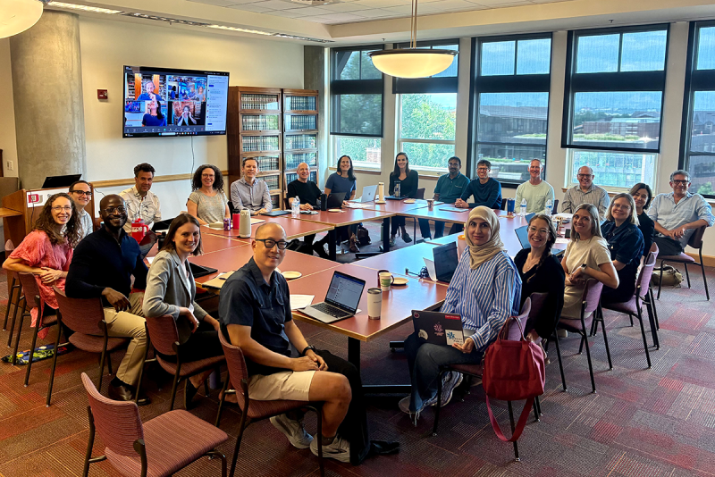 Faculty members seated around table in library
