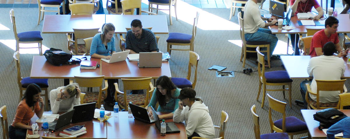 students at tables using laptops